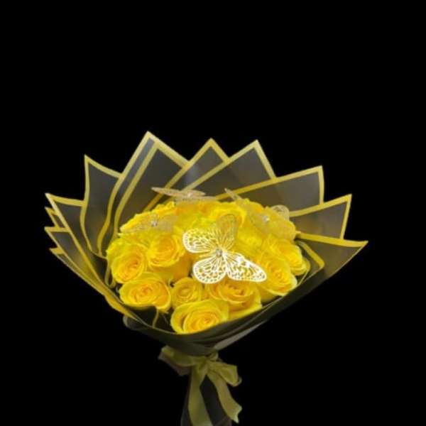 Yellow rose bouquet wrapped in dark paper with a ribbon