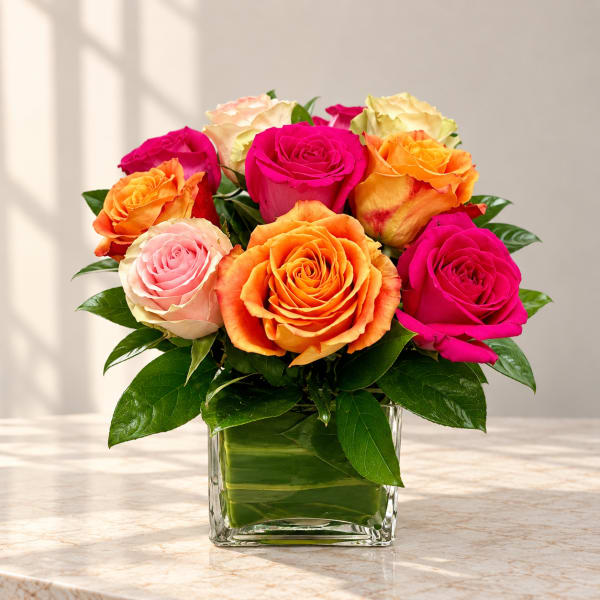Bouquet of multicolored roses in a clear square vase