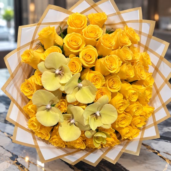 Bouquet of yellow roses with pale yellow orchids wrapped in white paper