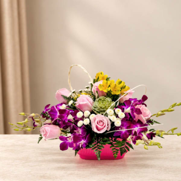 Pink roses and purple orchids arranged in a bright pink container