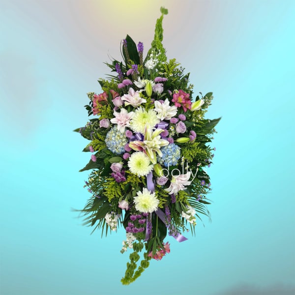 Tall mixed floral spray with lilies, roses, and hydrangeas in pink, white, and purple