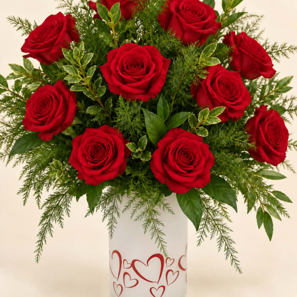 Red roses arranged in a white vase with heart designs