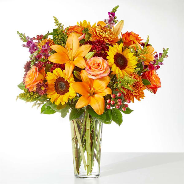 Orange and yellow mixed bouquet in a clear glass vase