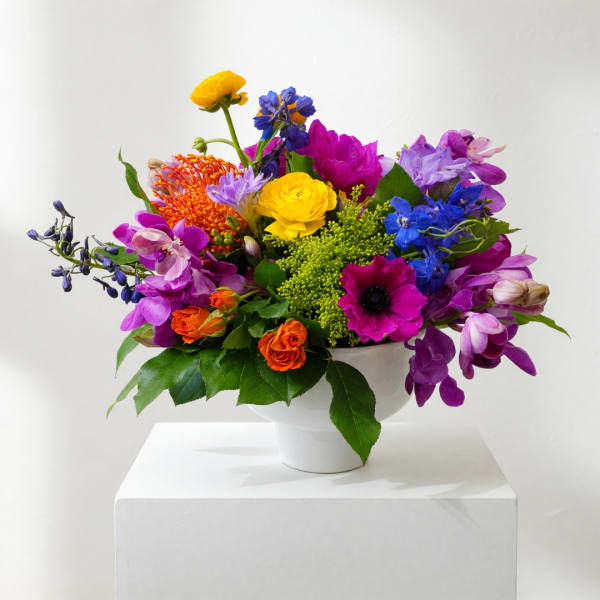 Colorful mixed flower arrangement in a white bowl vase