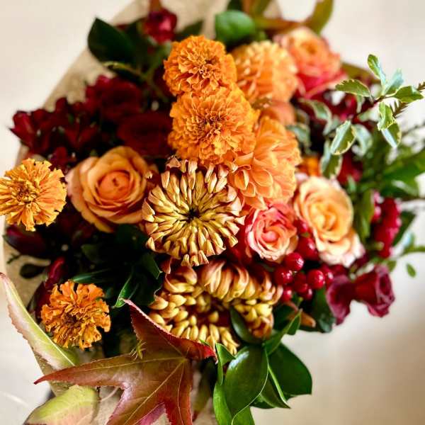 Bouquet of orange and red flowers wrapped in paper