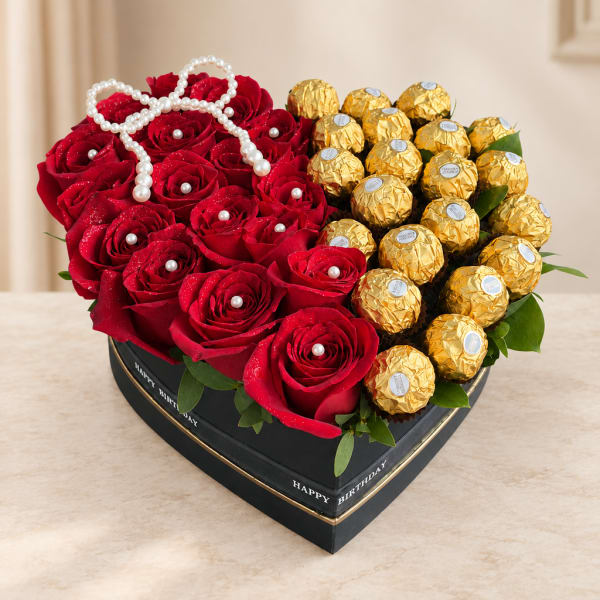 Heart-shaped box with red roses and gold-wrapped chocolates