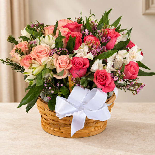 Basket of pink and white roses with a white ribbon