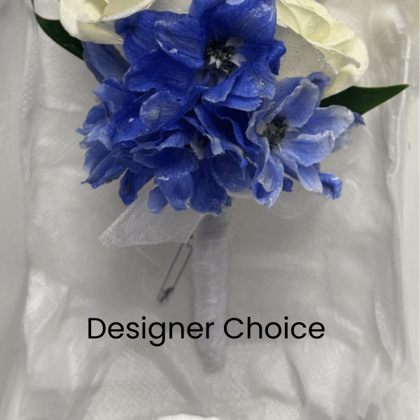 White rose and blue delphinium boutonniere with green leaves on white padding