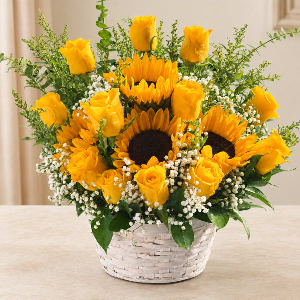 Yellow roses and sunflowers arranged in a white basket