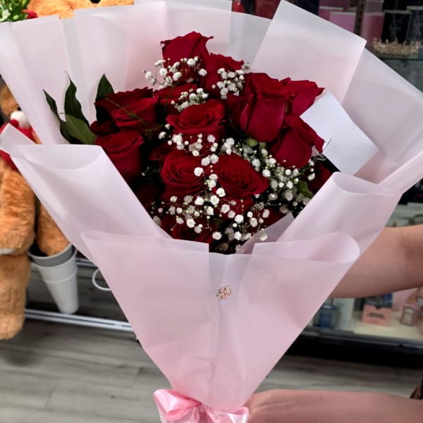 Bouquet of red roses with white baby's breath in pink wrapping