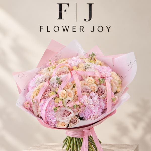 Large pink and cream bouquet wrapped in pink paper with ribbon
