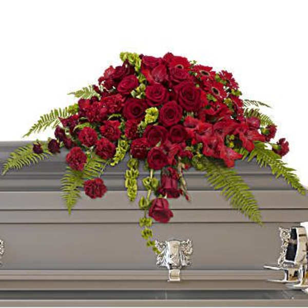 Red rose casket spray with trailing greenery
