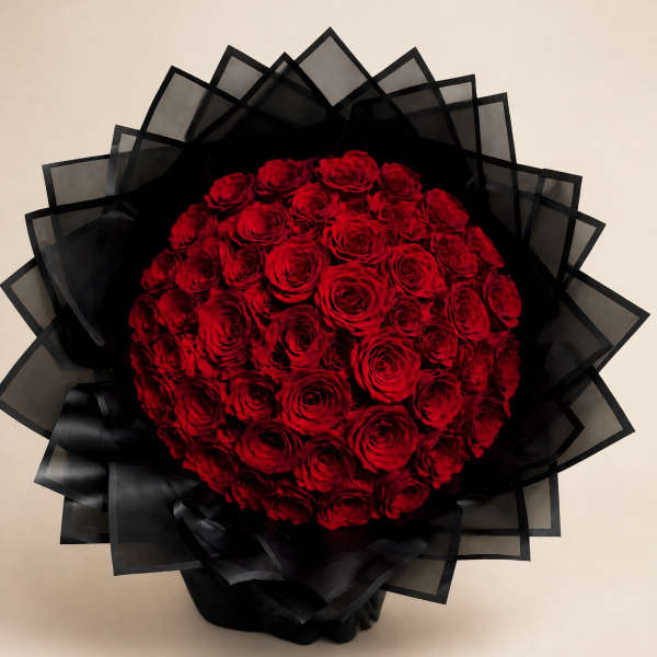 Round bouquet of red roses wrapped in black paper