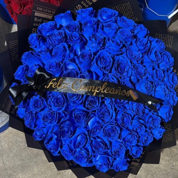 Bouquet of vivid blue roses with a black ribbon reading "Feliz Cumpleaños"