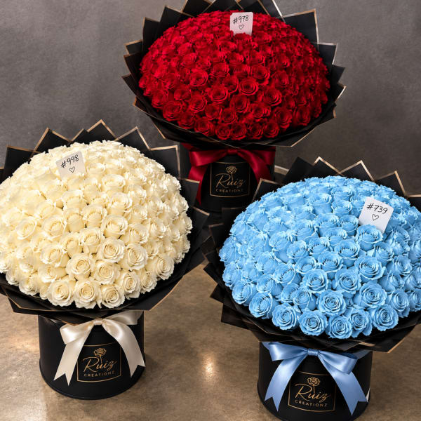 Three large rose bouquets in black boxes, in red, white, and blue.