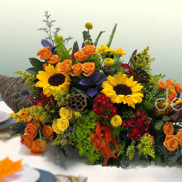 Colorful floral arrangement with sunflowers and orange roses in a low container