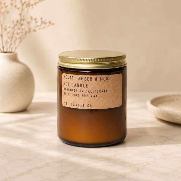 Amber soy candle in a glass jar with a gold lid
