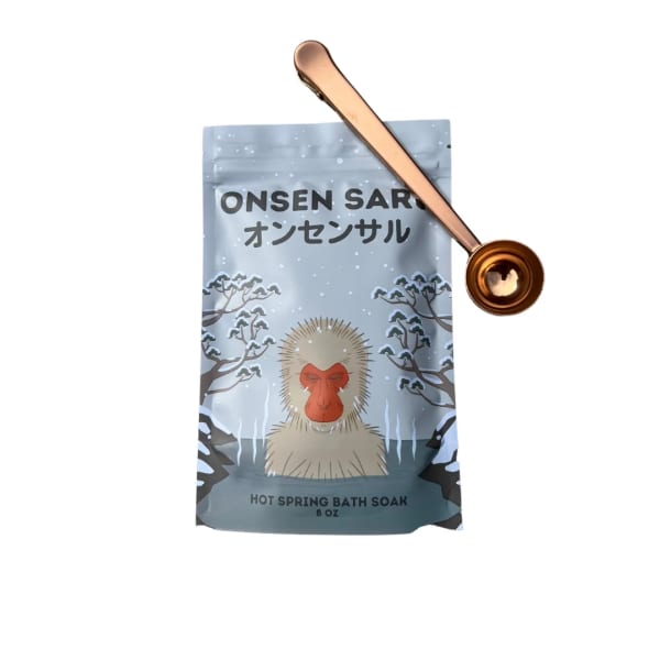 Bath soak pouch with a monkey illustration and a gold scoop