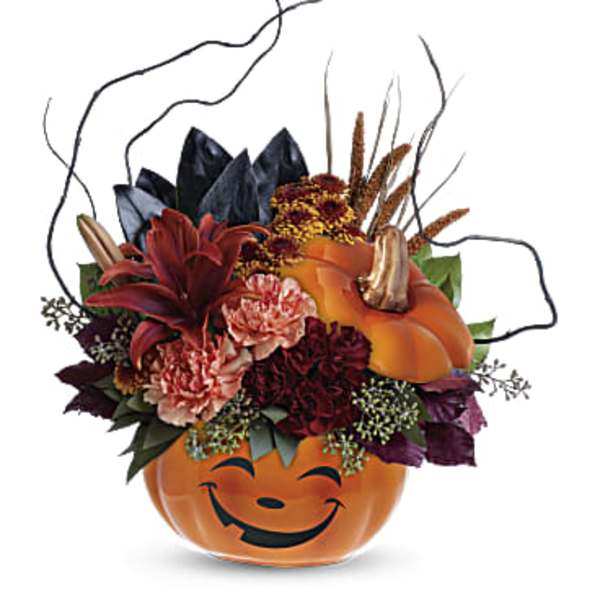 Halloween pumpkin container with mixed autumn flowers and curly branches