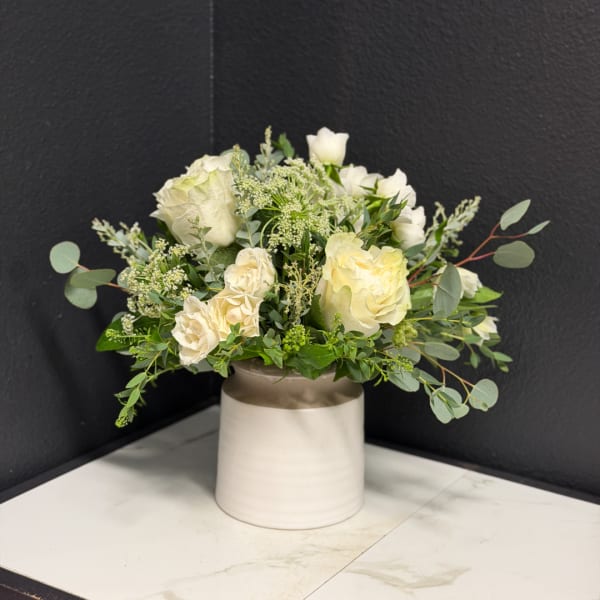 White rose bouquet in a cream ceramic vase
