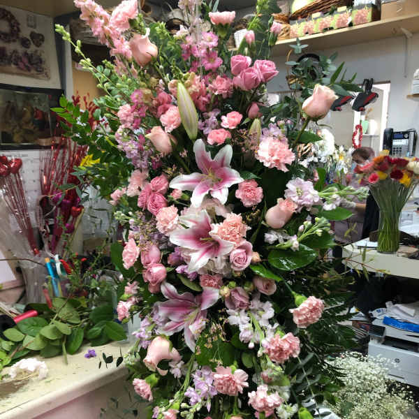 Tall pink floral spray with lilies, roses, and carnations