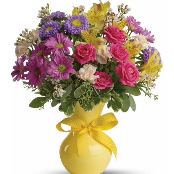 Mixed bouquet in a yellow vase with a ribbon bow