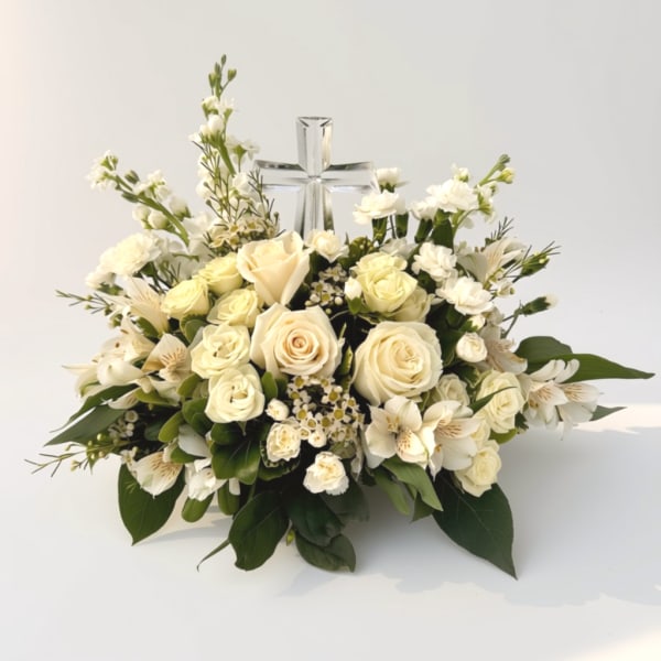 Cream rose and white flower arrangement with a clear glass cross