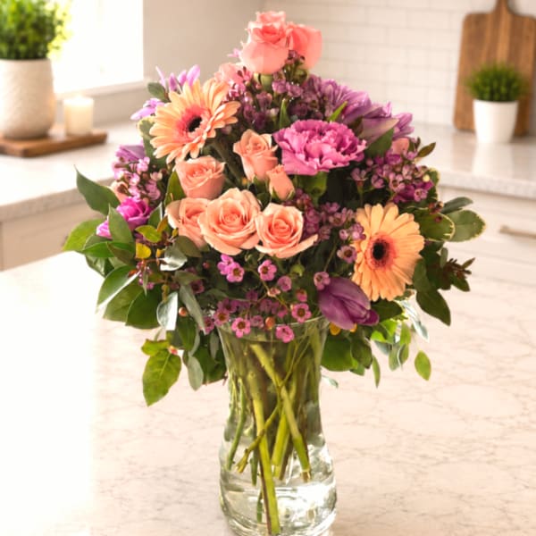 Mixed pink and purple bouquet in a clear glass vase