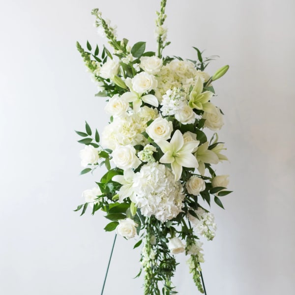 Tall white floral standing spray with roses, lilies, and hydrangeas