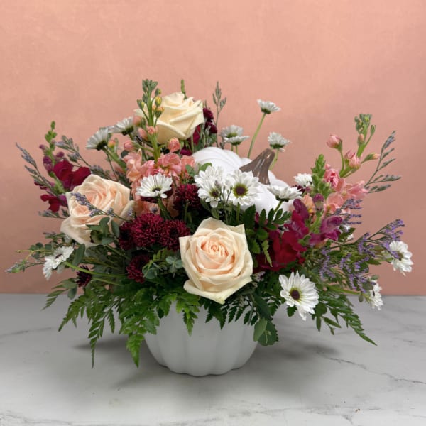 Mixed bouquet in a white pumpkin vase with cream roses and white daisies