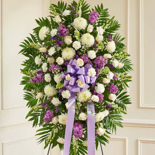 Standing floral spray with white and purple flowers and a lavender ribbon