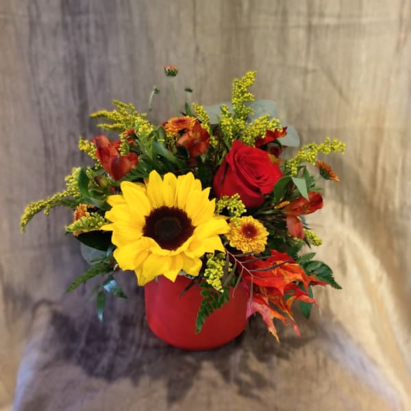 Sunflower and red rose arrangement in a red vase
