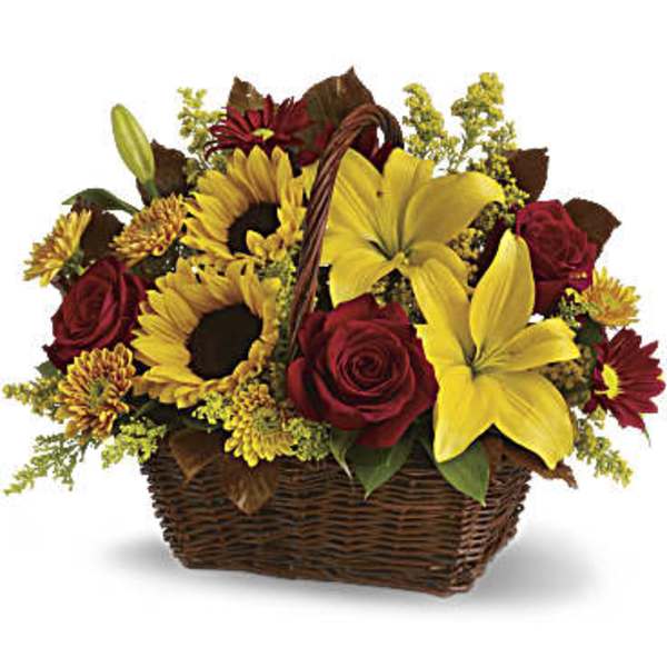 Basket arrangement with yellow lilies, sunflowers, red roses, and mums