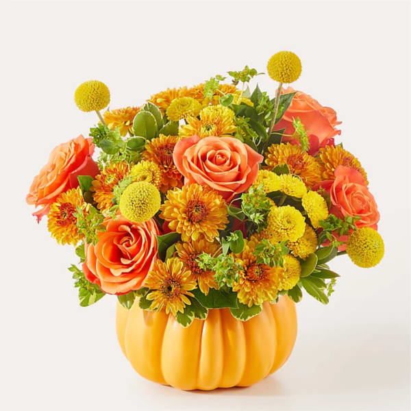 Orange roses and yellow mums arranged in a pumpkin-shaped vase