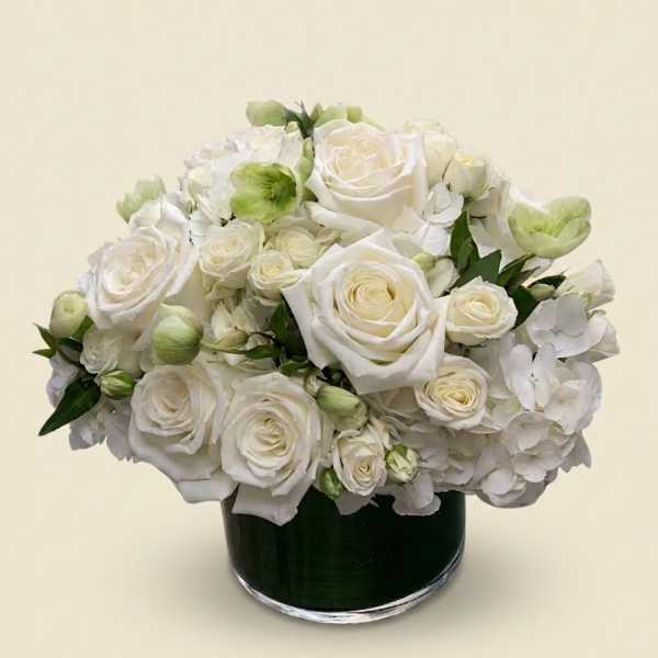 White rose and hydrangea arrangement in a dark glass vase