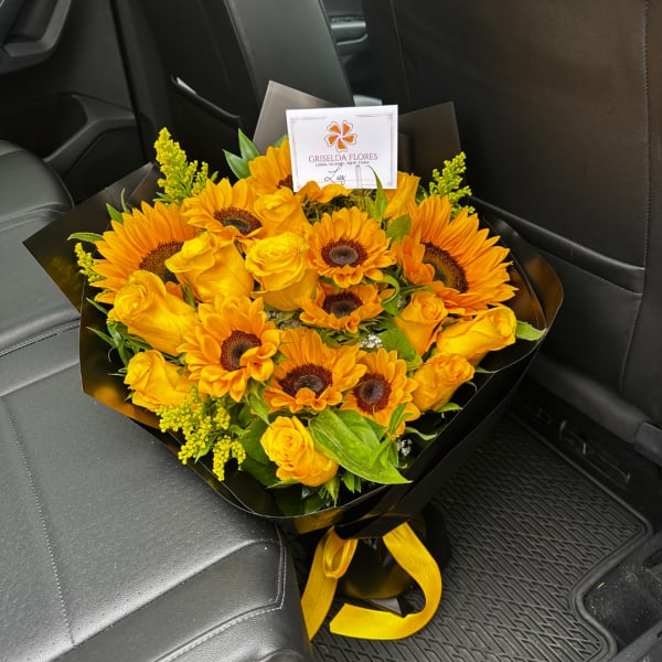 Bouquet of yellow sunflowers and roses wrapped in black paper