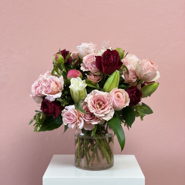 Bouquet of pink and burgundy roses in a clear glass vase