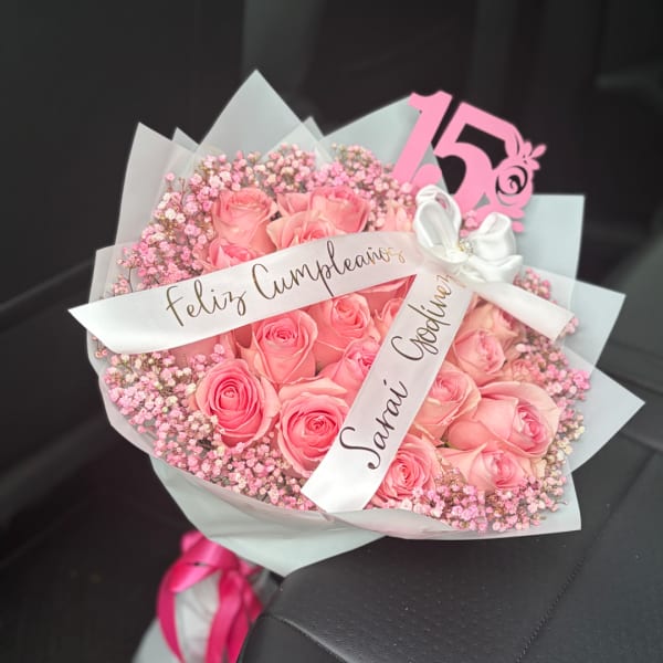 Pink rose bouquet with baby’s breath and a white ribbon