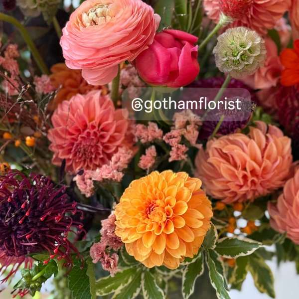 Mixed bouquet of pink, orange, and purple flowers in a vase