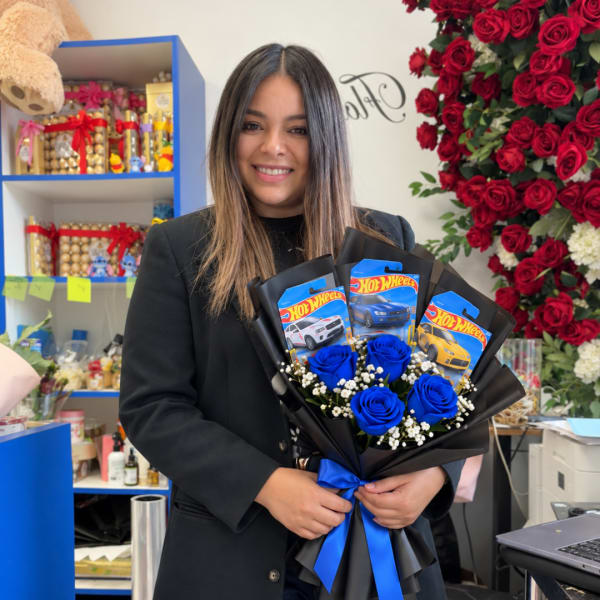 Woman holding a bouquet with blue roses and Hot Wheels cards