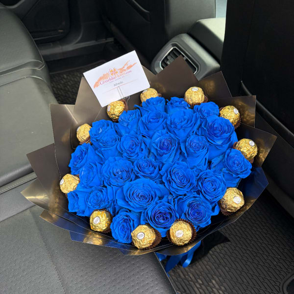 Blue rose bouquet with gold-wrapped chocolates in black paper