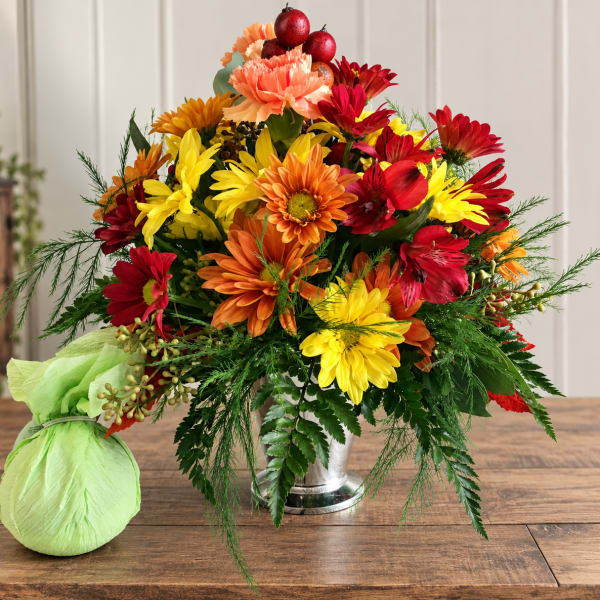 Bright mixed bouquet in a silver vase with a green wrapped accent