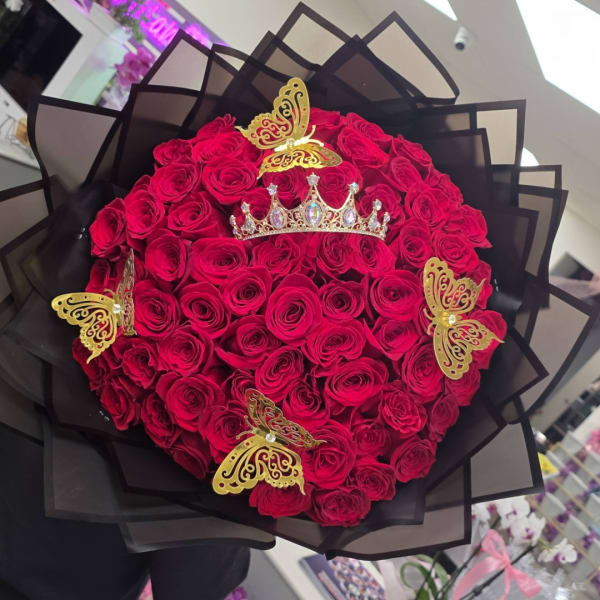 Bouquet of red roses with gold butterfly and crown decorations