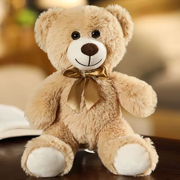Plush teddy bear with a gold ribbon bow