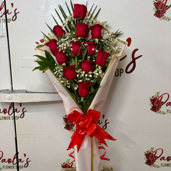 Bouquet of red roses with baby's breath wrapped in pink paper and a red ribbon
