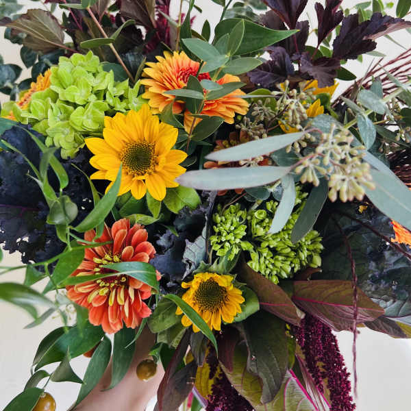 Mixed bouquet with sunflowers, orange blooms, and green hydrangea