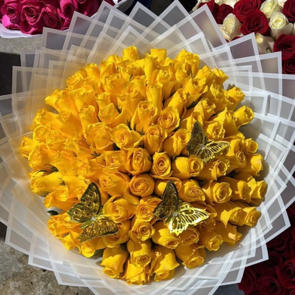 Bouquet of yellow roses wrapped in clear layered paper with butterfly decorations