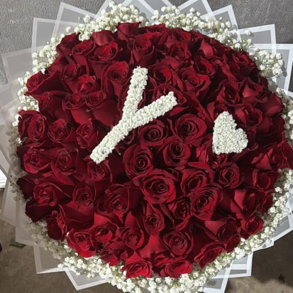 Round bouquet of red roses with white baby's breath accents