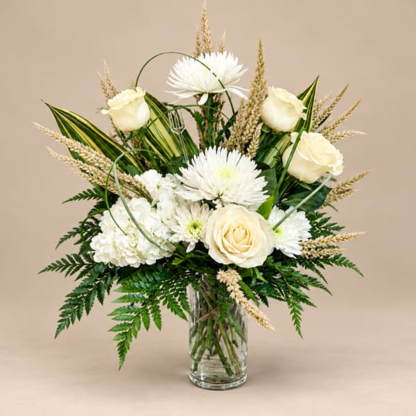 White roses and chrysanthemums in a clear glass vase