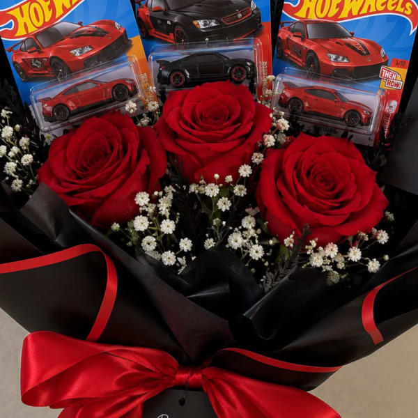 Bouquet of red roses with small white filler flowers and toy cars